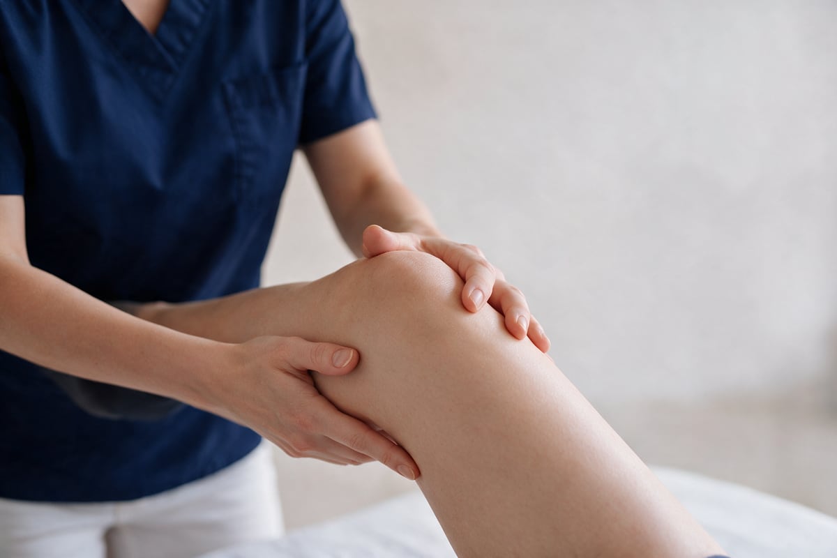 Physiotherapeutische Knieübung mit manueller Anleitung.